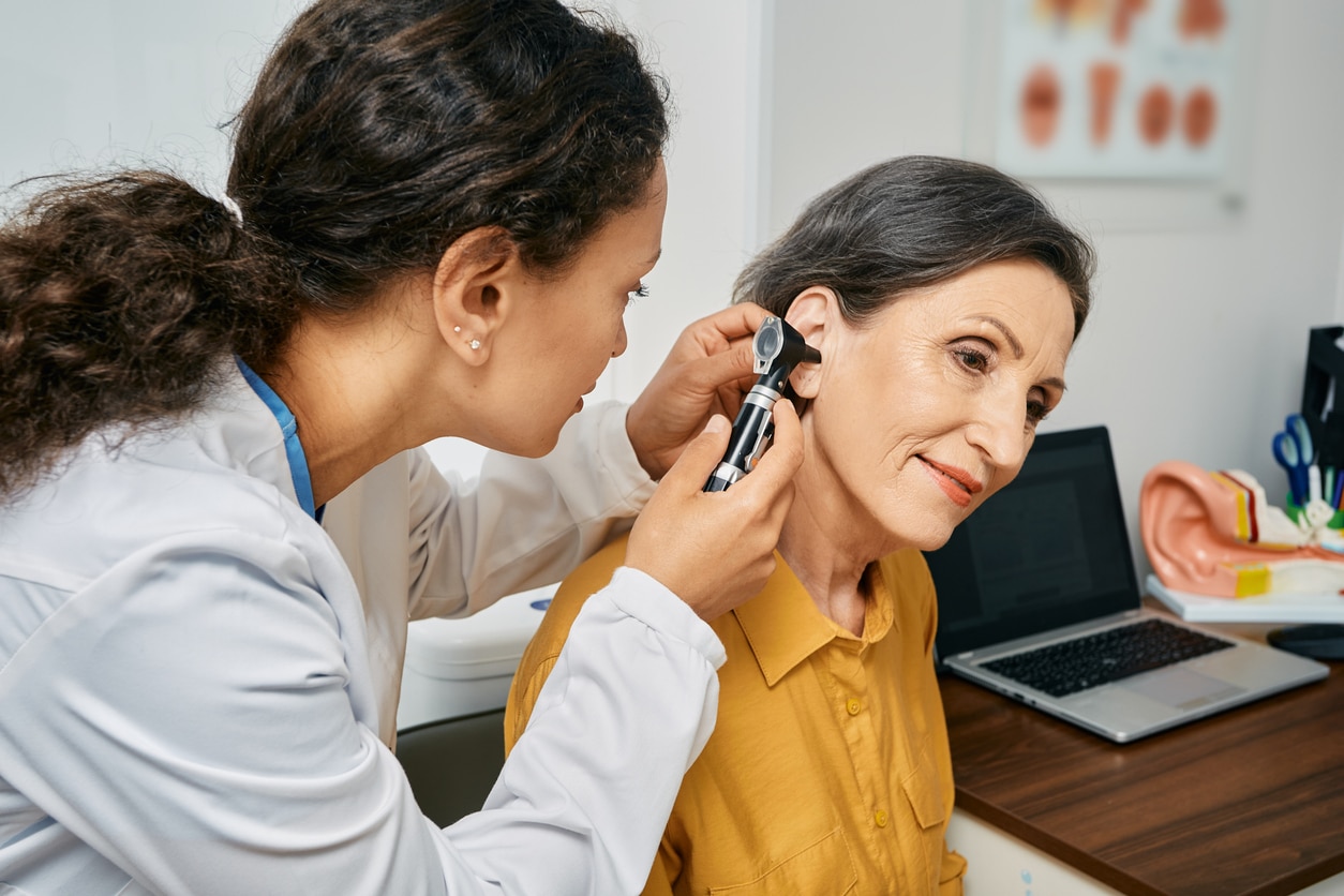 Doctor examines woman's ear