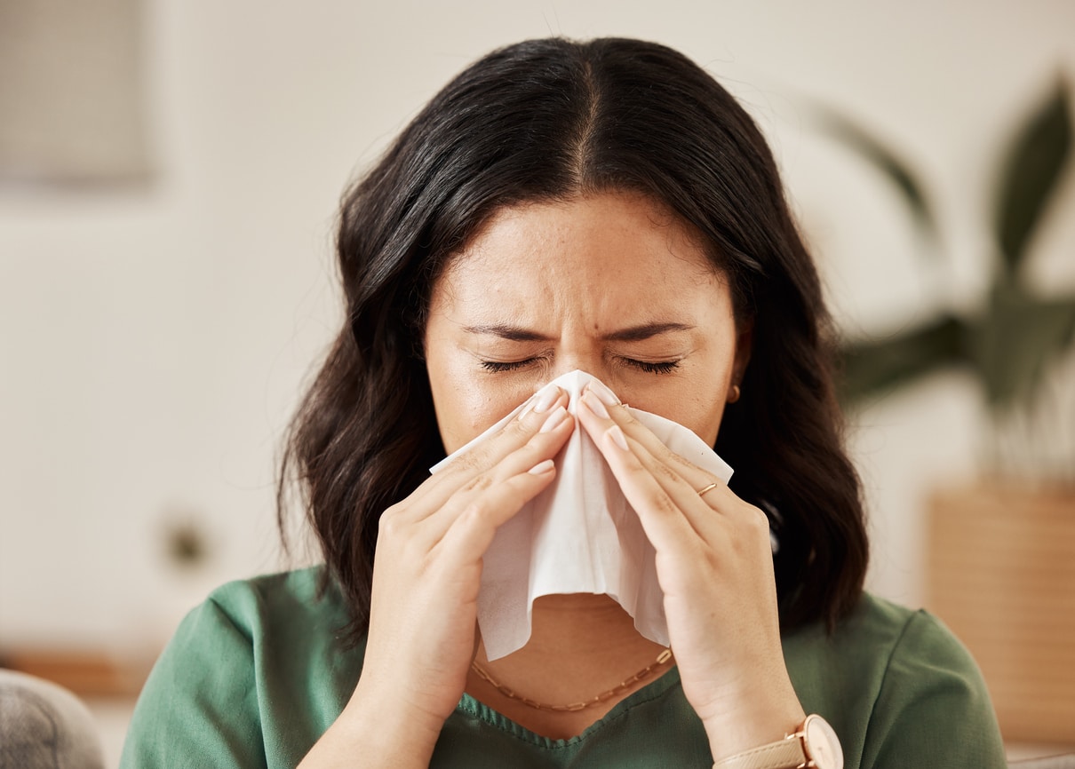 Woman blowing her nose.