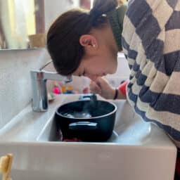 Woman with sinus pressure inhaling steam from a hot bowl of water