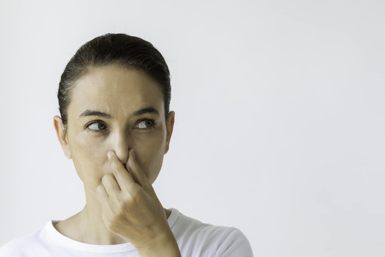 Woman pinching her nose.