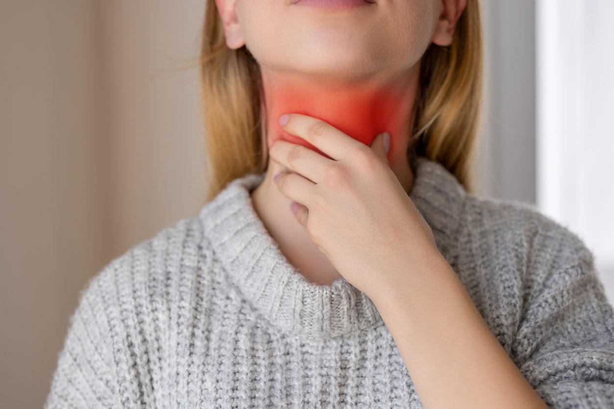 Woman with a red sore throat.